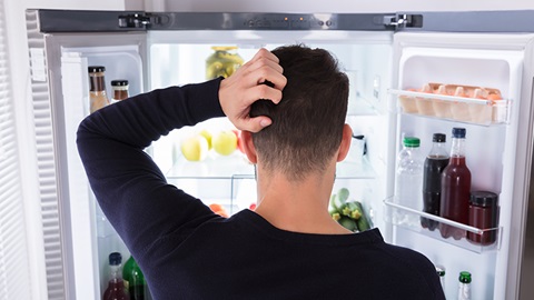 Une personne qui cherche dans son frigo
